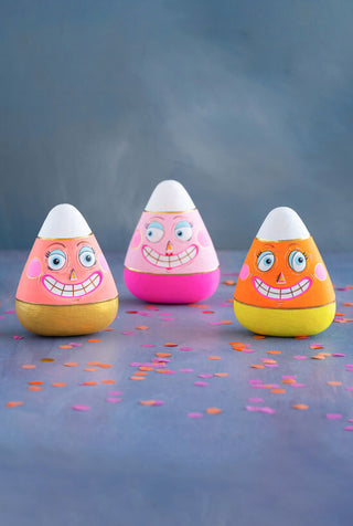 A set of three hand-painted, gold-leafed candy corn displays with colorful bodies and smiling faces.