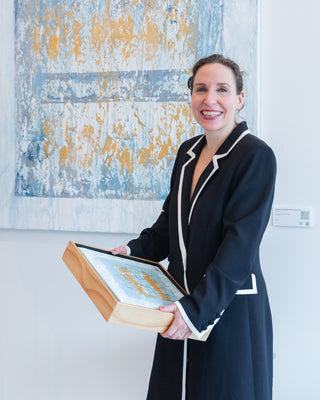 Ana Zampino with framed artwork at Atelier Modern gallery