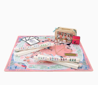 Set of stationery items including pens, a box, and a small bag on a decorative mat with a white background.