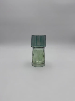 Green glass vase on a light gray background