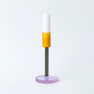 Candle holder with a white candle on a light gray background